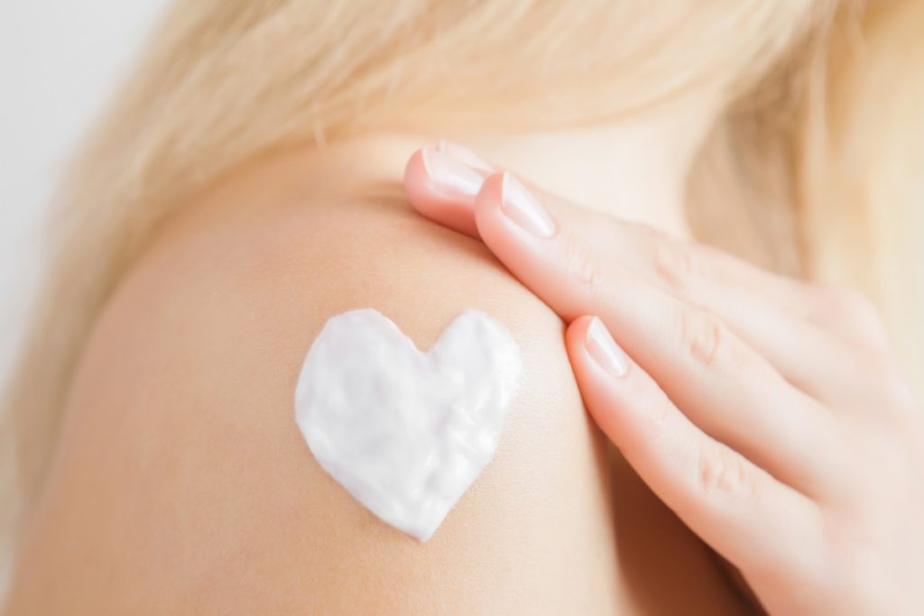 woman with heart shaped cream on skin